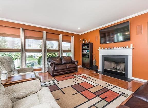 Roomy family room with wall of windows and wood burning fireplace.