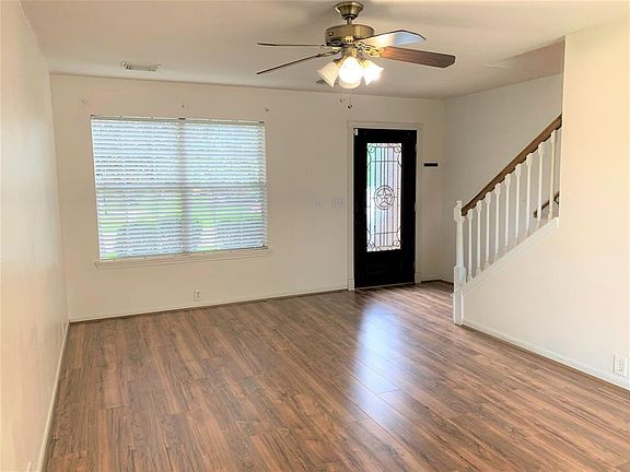 Neutral colors and wood plank laminate floors in the living area. The living area is open to the breakfast area