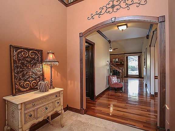 IMPRESSIVE ENTRY HAS TRAVERTINE FLOORING. Natural lighting makes this entryway light and bright. Two story entry looks up into the foyer of the game room with wrought iron balusters. The large entry is a great place for a welcoming bench!