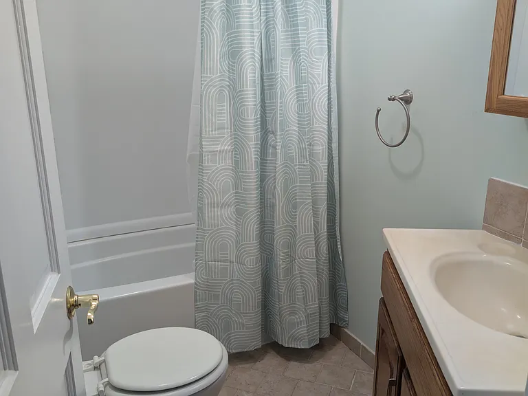 Bathroom on the second floor has tub/shower unit with tiled floors.