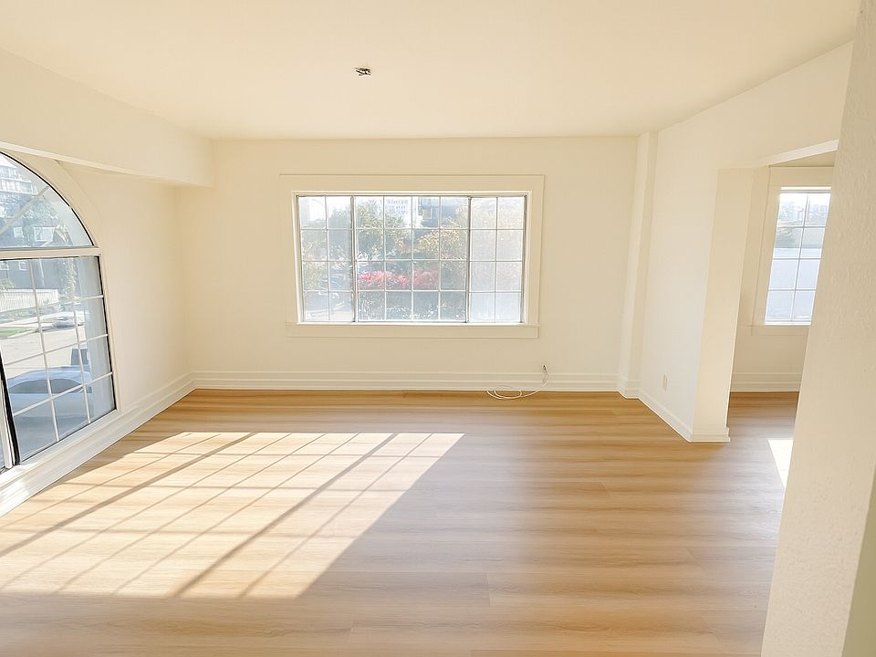 Enter through the front door into a spacious family room featuring expansive windows that fill the space with beautiful natural light.