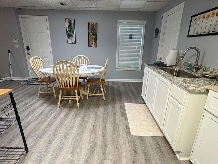 Open kitchen and dining area with granite-look counters, double-basin sink, and space for a full dining set.