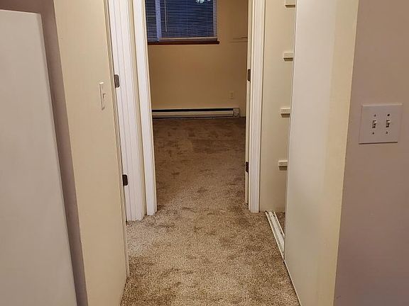 This is a view of the hallway down to the Master bedroom. There is some storage space on the right side as you can kind of see, some shelves for storage . You can see from this picture the freshly newly painted walls and new carpet.