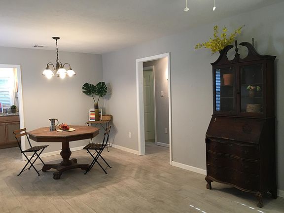 Another view of the living/dining room and hallway leading to first two bedrooms.