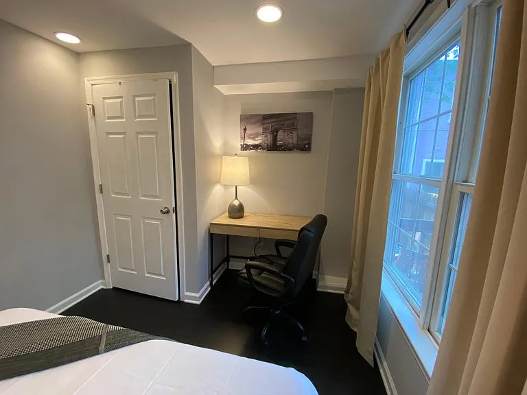 bedroom #1 on entry level features queen bed, desk, and lounge chair.
