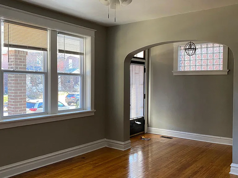 Front door and entryway lead into the living area through archway.