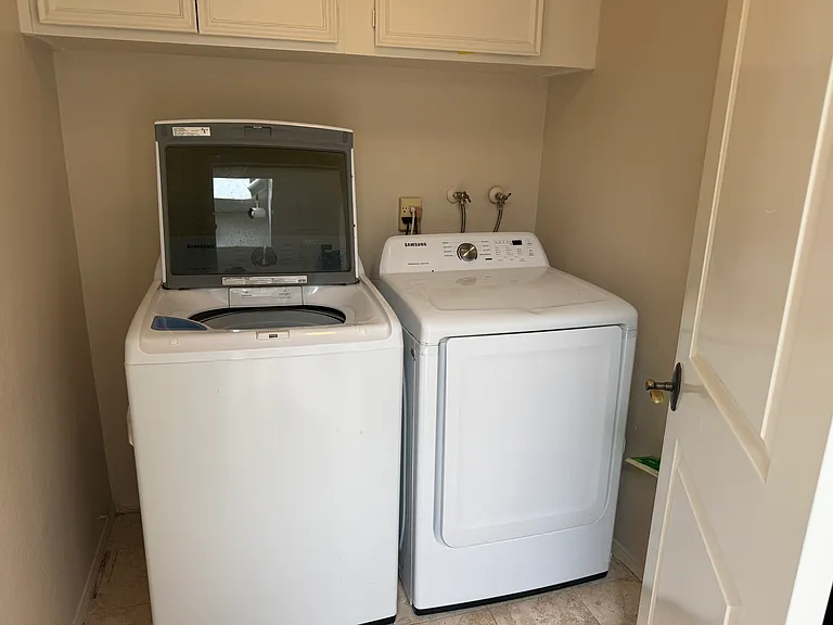 Laundry room next to kitchen with washer and dryer included