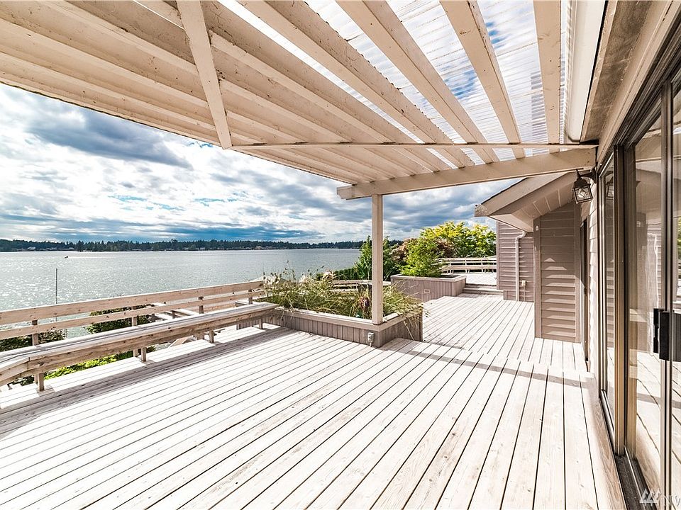 Captivating sunsets and views across the lake from this open water, western exposure, Tapps Island home*Expansive decking and wall of sliders to easily access the year round waterfront views