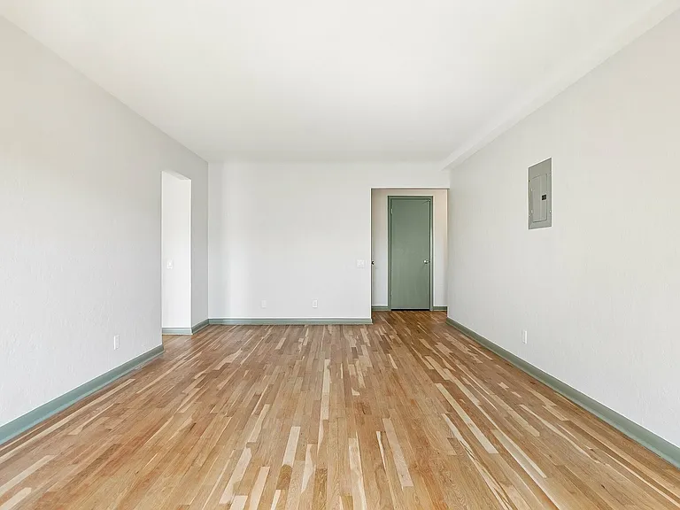 Bright and inviting empty room with polished hardwood floors and soft white walls, offering a blank canvas for personalized interior design.