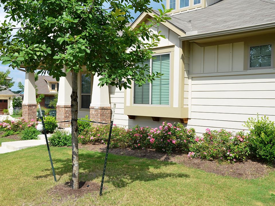 House, from the front. There is a sitting area in front of the door that can fit a large bench and several chairs.