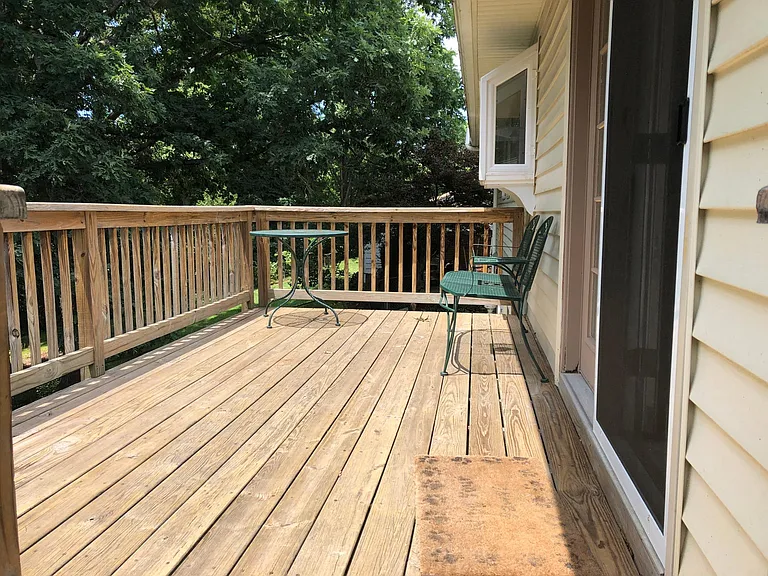 Back deck overlooking tree-covered backyard.