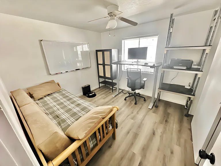 Second bedroom with a twin bed doubling as a couch and a twin bed hidden underneath. Also a stand up desk and monitor available for WFH.