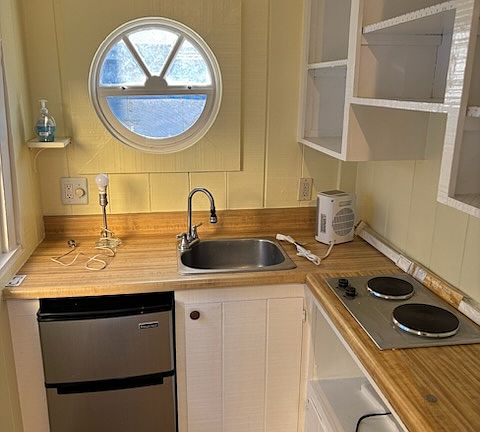 Fridge, sink, and cooktop, and heater. Happy to buy microwave if you want.