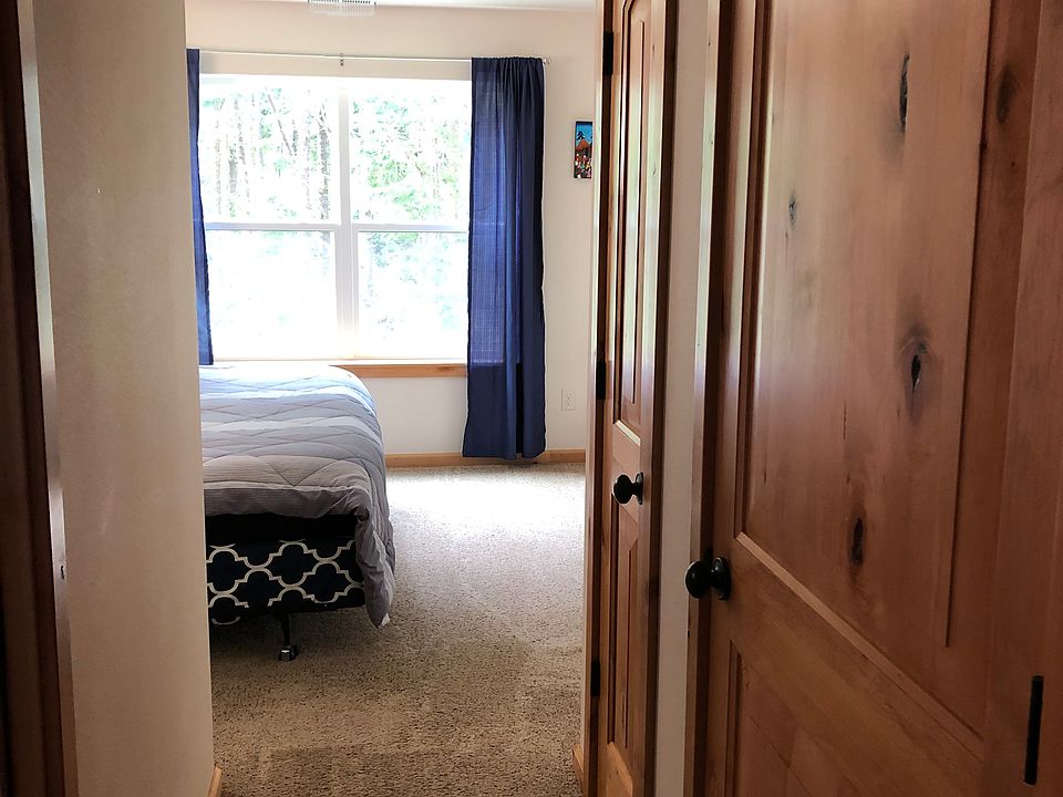 Looking into the master bedroom. Bathroom is to your left, large closet to your right, and lots of space to set up a home office or just relax, looking out to the privately maintained woods and trails behind the house.