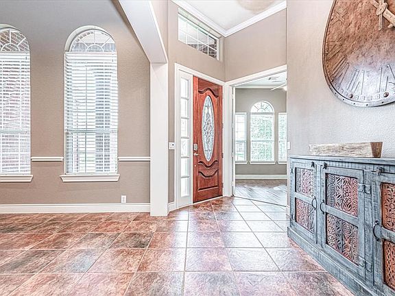 Front door view with formal dining room on the left and 2nd bedroom on the right with double french doors.