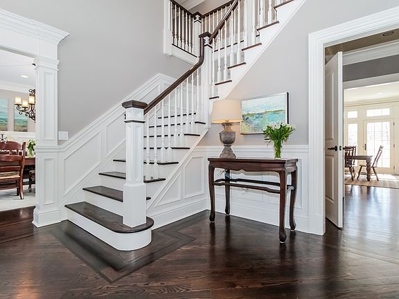 Double Height Foyer with Inlaid Wood Floor and Custom Moldings