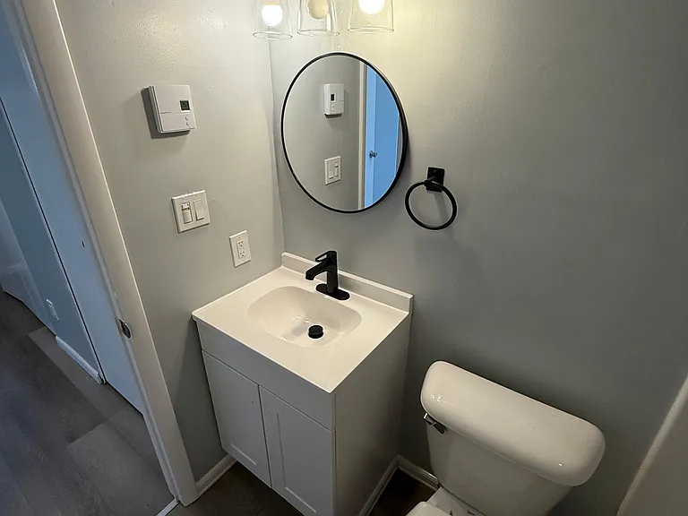 Upstairs newly renovated master bathroom with new vanity, mirror, lights, and appliances