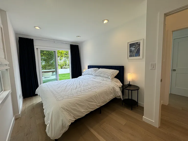 Primary bedroom features a new Casper King bed, navy velvet blackout curtains and a tv and dresser