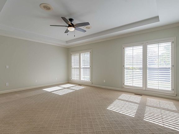 Master Bedroom with treyed ceiling, full length windows, plantation shutters and new ceiling fan.