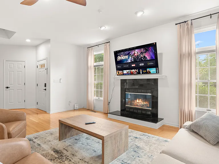 Inviting main living room with a cozy fireplace, comfortable furnishings, and large windows.
