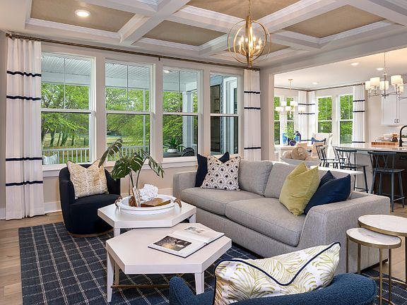 Living room with quadruple window, coffered ceiling and seating in a DRB Homes Barbados model home i