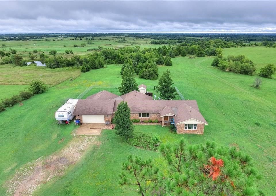 Ten lush acres of terrific land with two ponds AND a roomy, updated brick home!