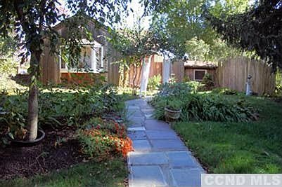 House is nestled amongst mature plantings and lush landscaping.