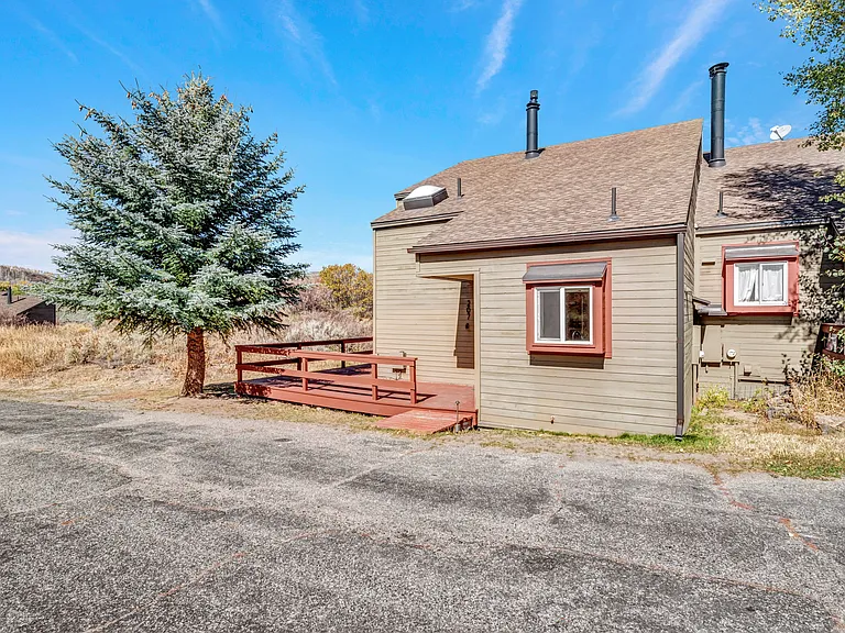 #207 is an end unit, with a wrap around front deck, small back storage shed, and parking area out front