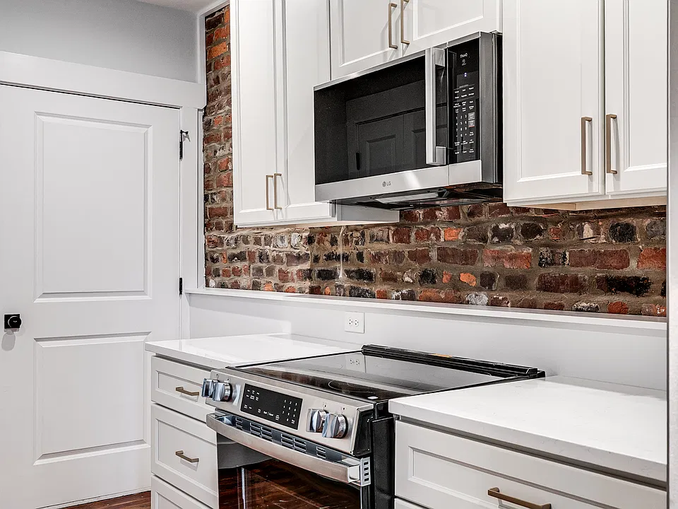 Exposed brick was retained with modern cabinets and upscale appliances. Large pull out drawers in the lower cabinets.