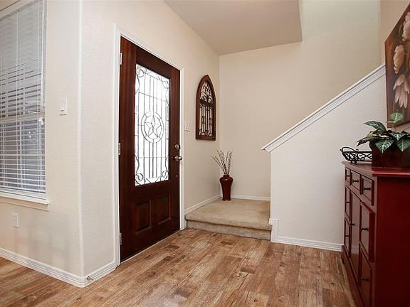 The front entry opens to the downstairs living space and kitchen or upstairs to the gameoom and primary bedroom suite.