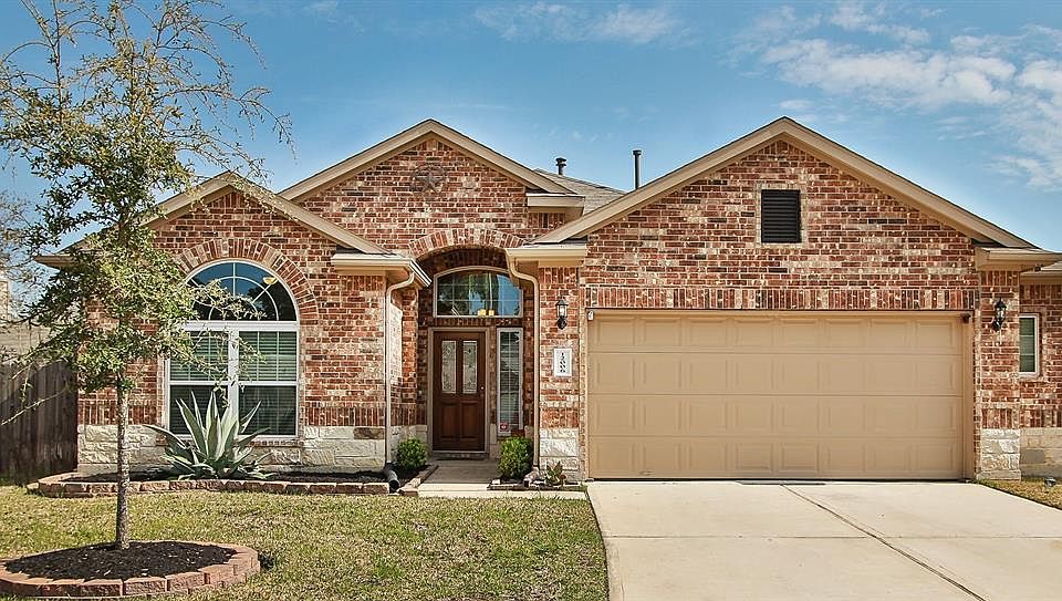 Legend homes Wyndham II floorplan with 3 sides brick, stone accent, and 5ft additional garage extension with window to right of home.