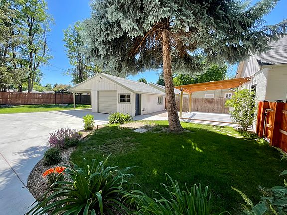 back of house including the carport, garage, back deck, fire pit, and fully fenced yard