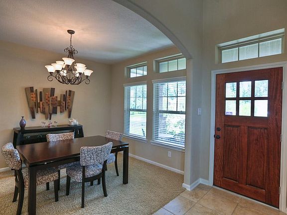 Gran entryway w/ leaded glass, solid wood door, & transom window accents.
