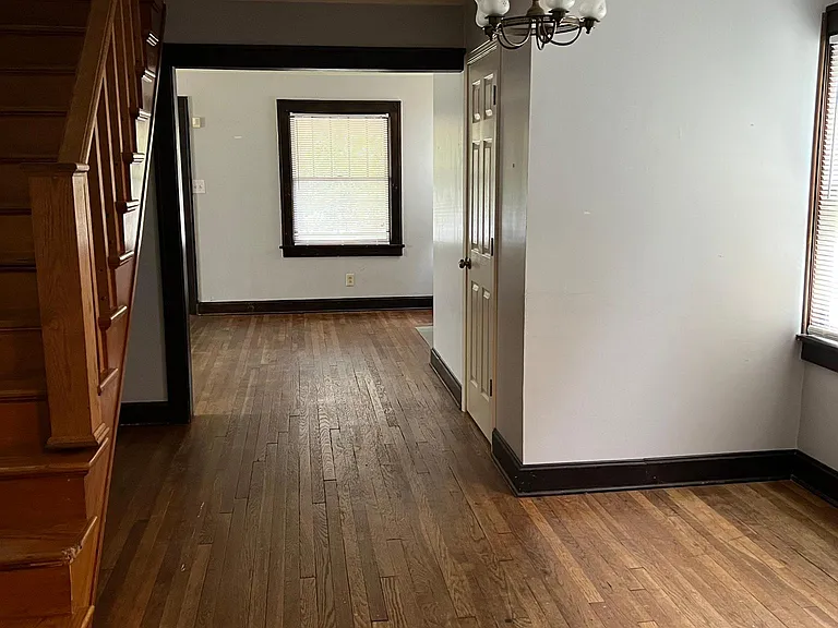 Dining room between kitchen and living room with beautiful wooden staircase up to 2nd floor.