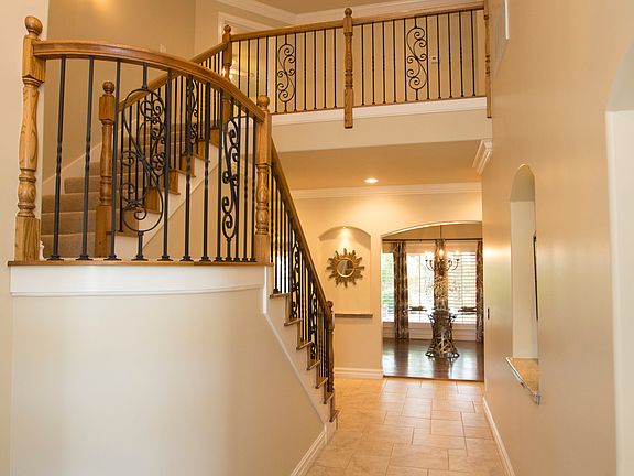 Alternate view of Foyer reveals winding stair case with iron baluster.