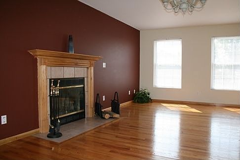 The living room features hardwood flooring, ample natural lighting and a cozy 