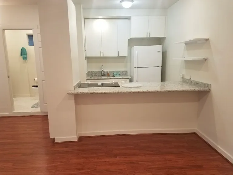 Open concept living room - silver fridge installed now. Granite countertops.