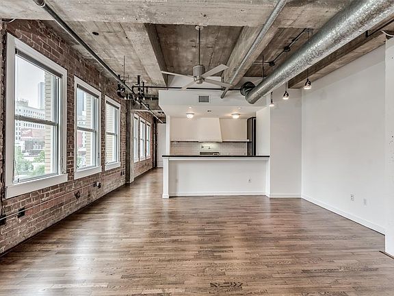 9 windows face over Travis Street offering amazing natural light in ALL ROOMS and views of Historic Market Square Park Area. Kitchen is separated from LR/DR by breakfast bar. To left of Kitchen is open hallway leading to mostly separated Primary Bedr