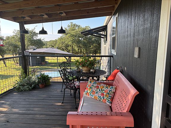 Front porch with view of cowboy pool and umbrella