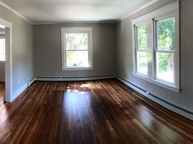 Living room - newly refinished floors, new baseboard, ceiling, trim, windows, baseboard heat and paint.