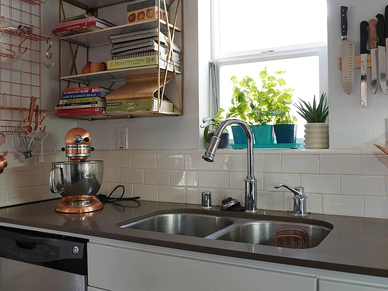 kitchen with marble shelving, stainless steel appliances (dishwasher)