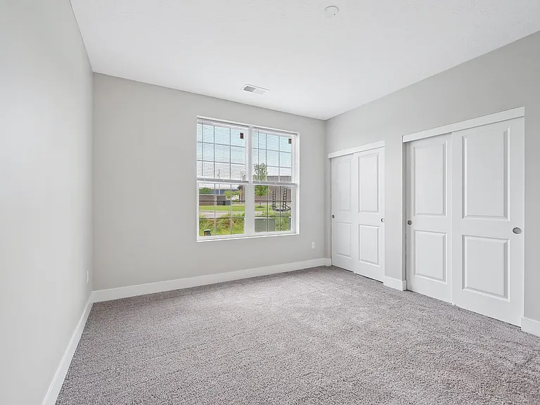 Dooley's Orchard unit showing a bedroom with a carpeted floor and window view.