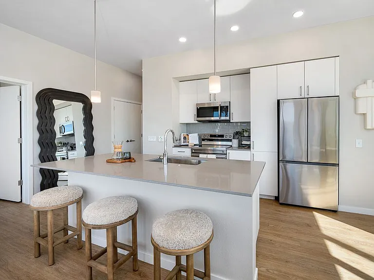 Finish Scheme I kitchen with grey quartz countertops, white cabinetry, grey subway tile backsplash, stainless steel appliances, and hard surface flooring