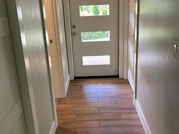 Front door entry with coat closet to right side of hall, lavatory to left, and laundry to left side