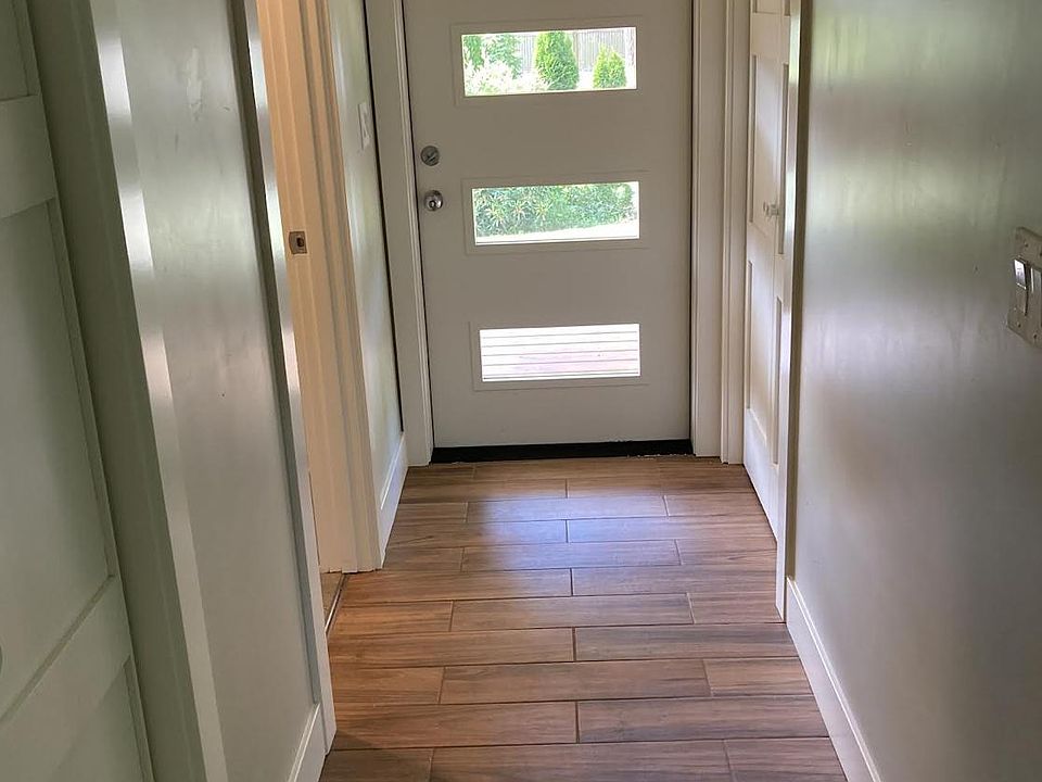 Front door entry with coat closet to right side of hall, lavatory to left, and laundry to left side