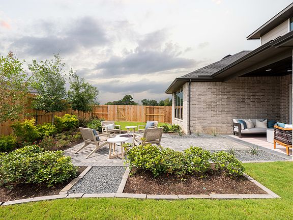 A well-designed outdoor living space with a patio, seating area, and lush landscaping, set against a