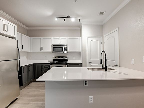 Spacious kitchen with hardwood style flooring and stainless steel appliances