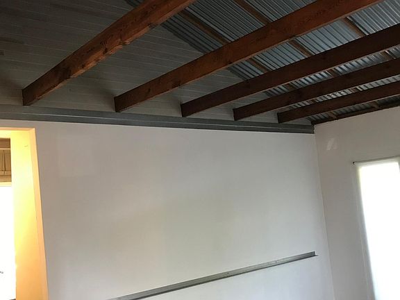 Main Living room w vaulted ceiling clad in corrugated metal panels