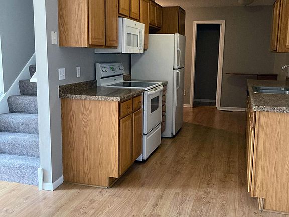 Kitchen into guest 1/2 bath, connected garage, and basement. Stairs on left to upper floor.