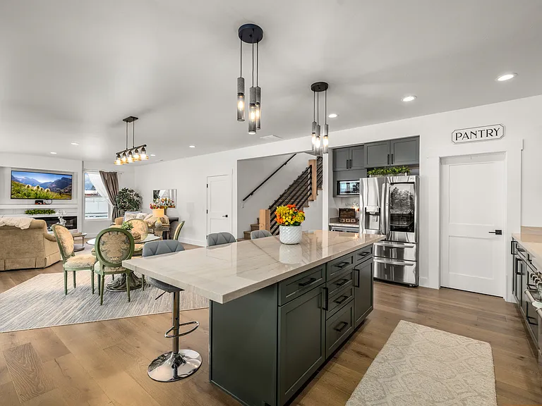 Beautifully connected kitchen, dining, and living areas filled with natural light, modern finishes, and stunning Montana views.